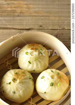 An overhead view of xiaolongbao steamed in a steamer basket 107296660