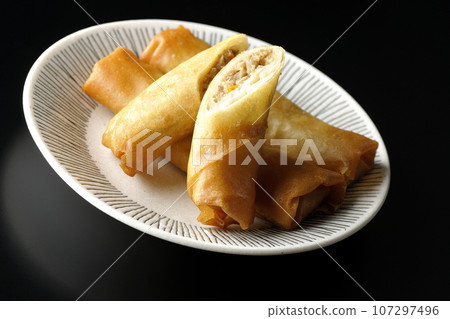在黑色背景下拍攝的一種點心春捲 在黑色背景下拍攝的一種點心春捲 107297496
