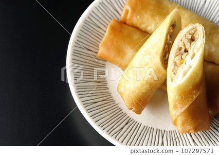 An overhead shot of a type of dim sum spring roll against a black background 107297571