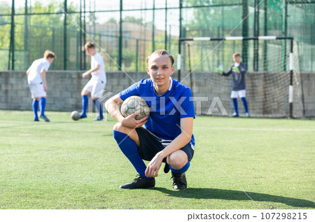 Youth football player sitting on field Youth football player sitting on field 107298215