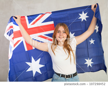 smiling girl in arms raised above head holds canvas of national flag of Australia smiling girl in arms raised above head holds canvas of national flag of Australia 107298452