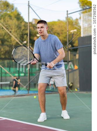 Boy tennis player training on court Boy tennis player training on court 107298562