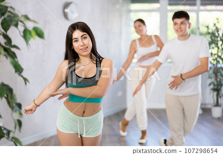 Hispanic teenage girl practicing energetic dance in choreography class 107298654