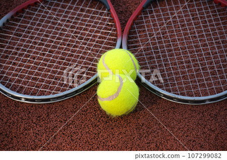 Tennis ball, racquet on hard court surface 107299082