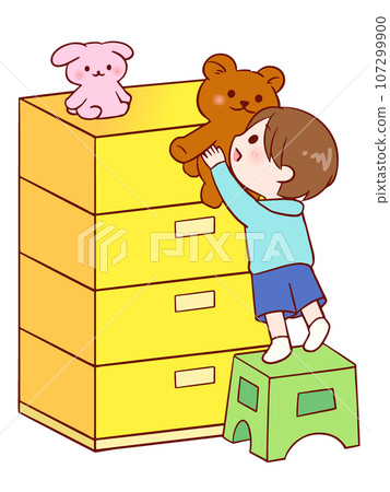 一個男孩用一個架子從抽屜櫃拿起一個毛絨動物。 一個男孩用一個架子從抽屜櫃拿起一個毛絨動物。 107299900