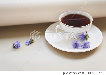 The composition of a hot drink made of chicory, cups and saucers on a wooden table with a place to copy. A healthy drink made from chicory. High quality photo The composition of a hot drink made of chicory, cups and saucers on a wooden table with a place to copy. A healthy drink made from chicory. High quality photo 107300779