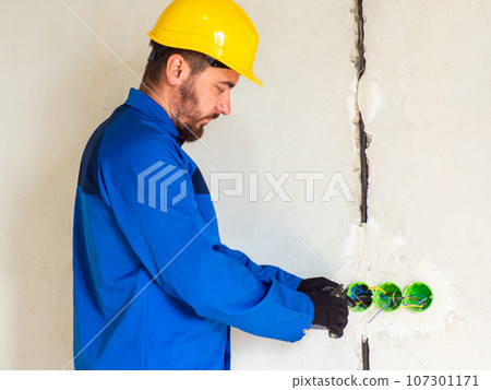 Professional electrician working on home electrical system 107301171