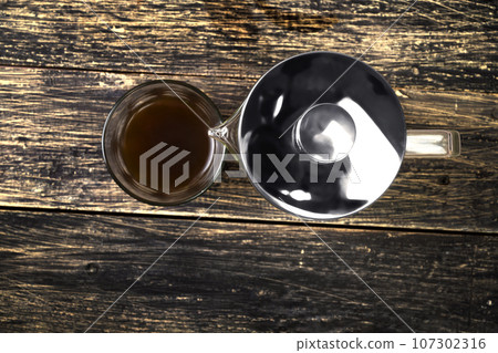 A cup of coffee and a French press coffee maker A cup of coffee and a French press coffee maker 107302316