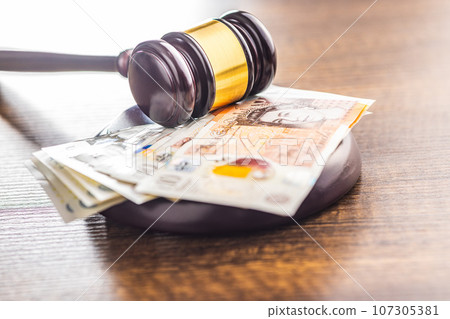 Judge gavel and british pound sterling on wooden table. Judge gavel and british pound sterling on wooden table. 107305381