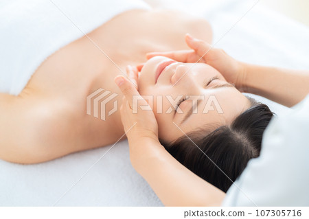 A middle-aged woman doing skin care at a beauty salon 107305716