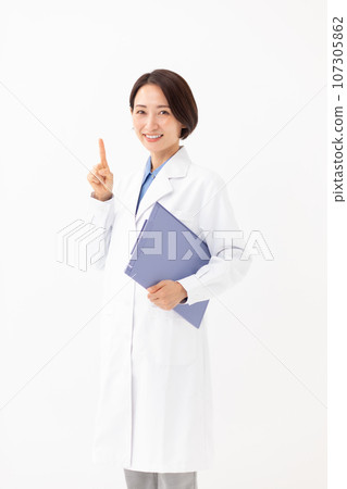A woman in a white coat holding a medical record, pointing 107305862