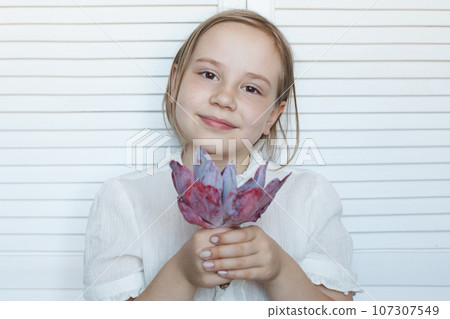 Cute child girl holding flowers on white background Cute child girl holding flowers on white background 107307549