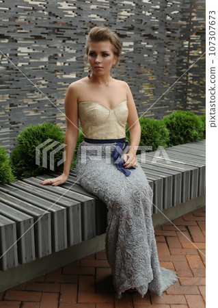 Glamorous young model woman in evening gown in mansion yard 107307673