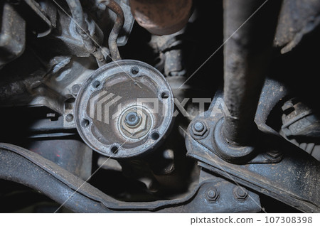 The driveshaft flange under the bottom of the car. Automotive background of transmission repair and driveshaft restoration 107308398