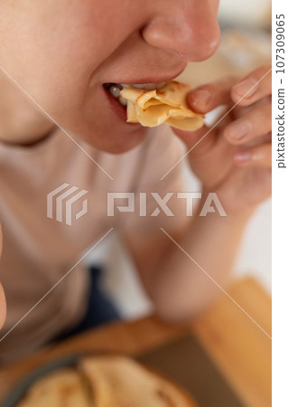 woman having breakfast with pancakes in her kitchen 107309065