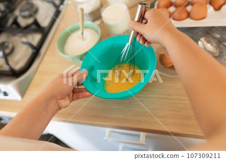 the process of beating eggs in an omelet bowl 107309211