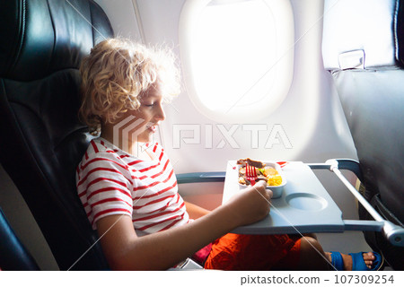 Child in airplane. Kids fly. Children flight meal Child in airplane. Kids fly. Children flight meal 107309254