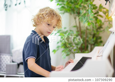 Child playing piano. Kids play music. Child playing piano. Kids play music. 107309290