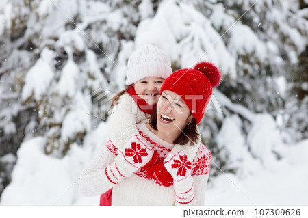 Mother and child in knitted winter hats in snow. Mother and child in knitted winter hats in snow. 107309626