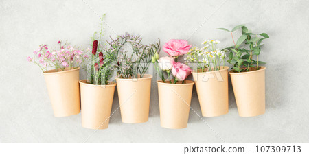 Paper cups with spring flowers, zero waste concept Paper cups with spring flowers, zero waste concept 107309713