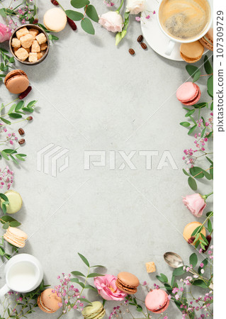 Coffee time concept. Frame made of Spring flowers, different types of macaroons and coffee flat lay Coffee time concept. Frame made of Spring flowers, different types of macaroons and coffee flat lay 107309729
