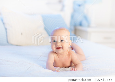 Baby boy on white bed Baby boy on white bed 107310437