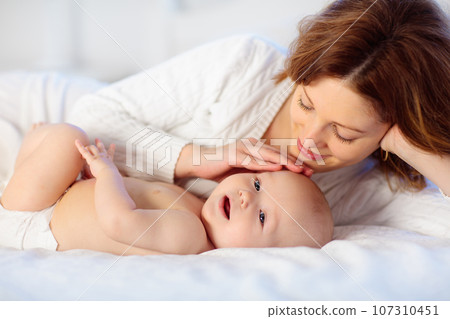 Mother and baby on a white bed Mother and baby on a white bed 107310451