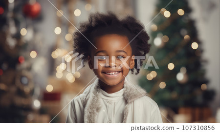 Portrait of a happy black child near the New Year tree on Christmas Eve. Portrait of a happy black child near the New Year tree on Christmas Eve. 107310856