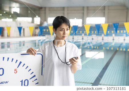A woman measuring her time in an indoor pool A woman measuring her time in an indoor pool 107313181
