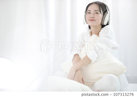 年輕女子在床上放鬆聽音樂 107313276