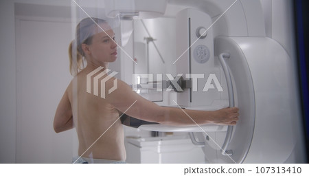 Caucasian woman stands topless in hospital radiology room 107313410