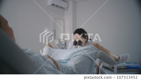 Woman lies on gynecological chair during colposcopy procedure Woman lies on gynecological chair during colposcopy procedure 107313452