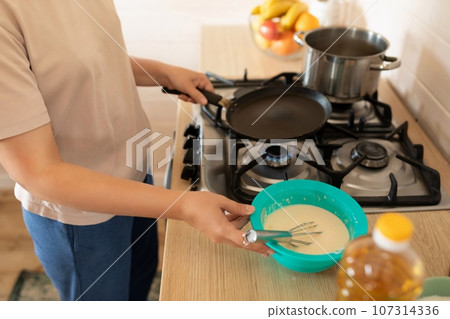 Close-up of a frying pan, gas stove while cooking pancakes 107314336