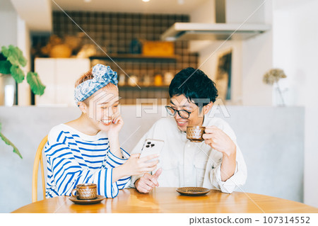 Young couple looking at smartphone together Young couple looking at smartphone together 107314552
