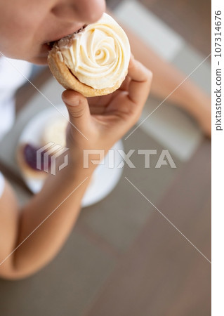 a woman stuffs a tartlet into her mouth. concept of weight gain and diet failure a woman stuffs a tartlet into her mouth. concept of weight gain and diet failure 107314676