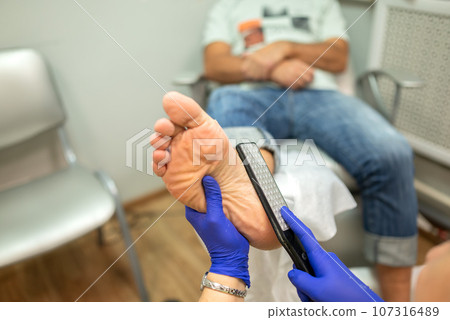 concept of male pedicure, cosmetologist makes classic pedicure for an elderly male client. concept of male pedicure, cosmetologist makes classic pedicure for an elderly male client. 107316489