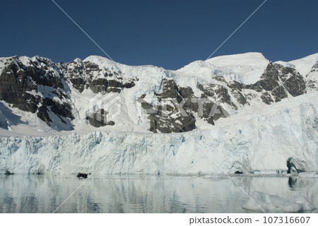 Tourists watching glaciers and mountains in Paradise bay, Antarctic peninsula, Antartica.. Tourists watching glaciers and mountains in Paradise bay, Antarctic peninsula, Antartica.. 107316607