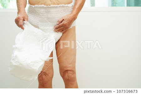 Asian senior woman patient wearing adult incontinence diaper pad in hospital. 107316673