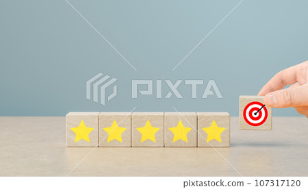 customer hand put wooden blocks with target and five yellow star symbol. Improve rating, increase ranking, improve customer satisfaction concept 107317120