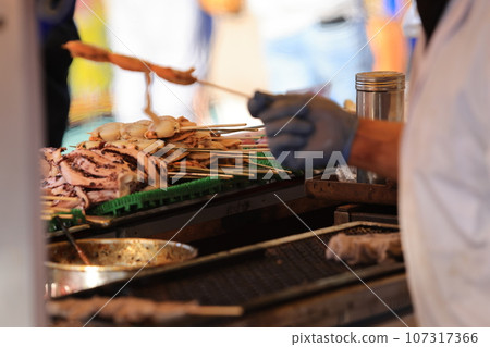 skewer pork and seafood in japanese food stall in the food market of Asakusa, japan skewer pork and seafood in japanese food stall in the food market of Asakusa, japan 107317366