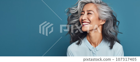 Middle-aged Asian woman with a short gray hairdo looking at copy space. Middle-aged Asian woman with a short gray hairdo looking at copy space. 107317405