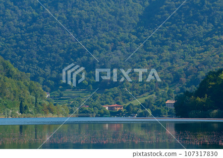 Panoramic lake Lago di Segrino against huge mountain background, in Lombardy, Italy. Travel. Nature. Tourism Panoramic lake Lago di Segrino against huge mountain background, in Lombardy, Italy. Travel. Nature. Tourism 107317830