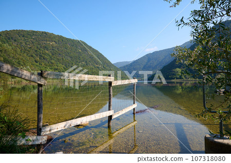 Panoramic lake Lago di Segrino against huge mountain background, in Lombardy, Italy. Travel. Nature. 107318080