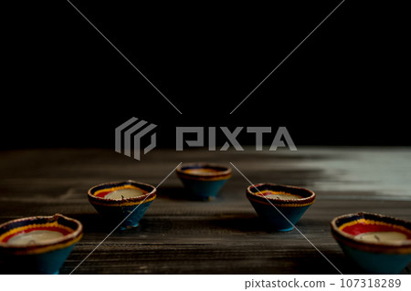 Happy Diwali - Clay Diya lamps lit during Dipavali, Hindu festival of lights celebration. Happy Diwali - Clay Diya lamps lit during Dipavali, Hindu festival of lights celebration. 107318289