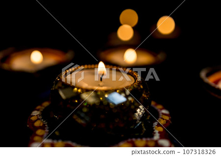 Happy Diwali - Clay Diya lamps lit during Dipavali, Hindu festival of lights celebration. 107318326
