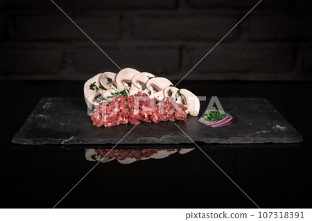 Minced meat and mushrooms, pork beef farce, dark background 107318391