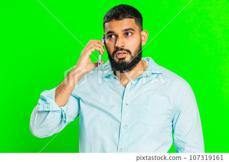 Disinterested tired Indian man having annoyed boring talk on smartphone online conversation, quarrel Disinterested tired Indian man having annoyed boring talk on smartphone online conversation, quarrel 107319161