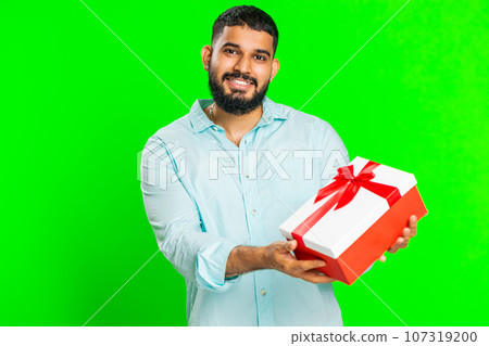 Smiling man presenting birthday gift present box stretches out hands, promotion discount sale 107319200