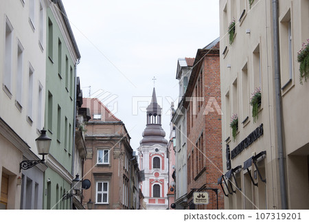 Poznan is the oldest city in Poland. The pink main tower of the Fala church can be seen from the streets of the old town. 107319201
