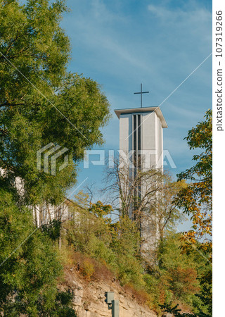 Modern Church Tower with Big Metal Cross. Modern church tower crowned with iron crosses on sunset sky background 107319266